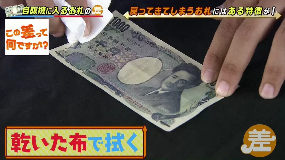 乾いた布でお札を拭く